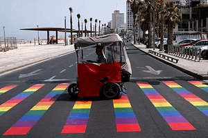 People ride over a rainbow-colored pedestrian crossing before the gay pride parade in Tel Aviv on June 3, 2016. BAZ RATNER/REUTERS